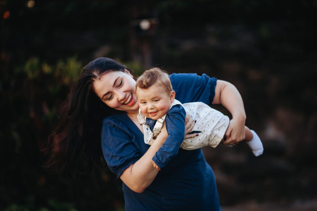Mãe sorrindo segurando bebê saudável ao ar livre
