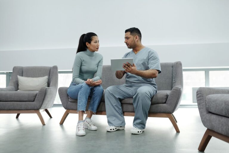 Profissional de saúde conversando com paciente segurando tablet